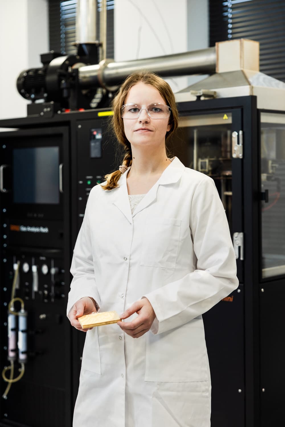 Specjalistka laboratorium z próbką 100 × 100 mm przed kalorymetrem stożkowym
